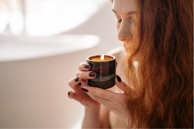 Woman Holding Candlelit Coffee Cup