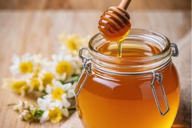 Honey Dripping Into Glass Jar