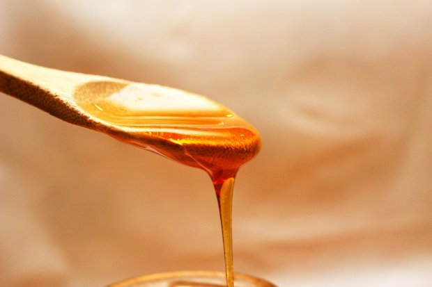 Honey Dripping From Wooden Spoon